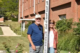 John Lersch ’79 (right) poses with the Peace Pole